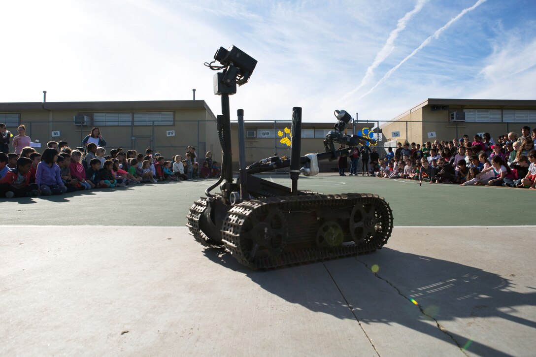 Dingeman Elementary School students observe the Mark II Talin as it demonstrates its capabilities during the EOD demonstration at Dingeman Elementary School in San Diego, Calif., Mar. 15. The Marines conducted this demonstration to teach students about robotics as well as form stronger relations with the surrounding community. (U.S. Marine Corps photo by Lance Cpl. Cheng Chang)