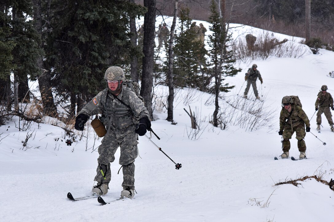 Soldiers ski down a trail