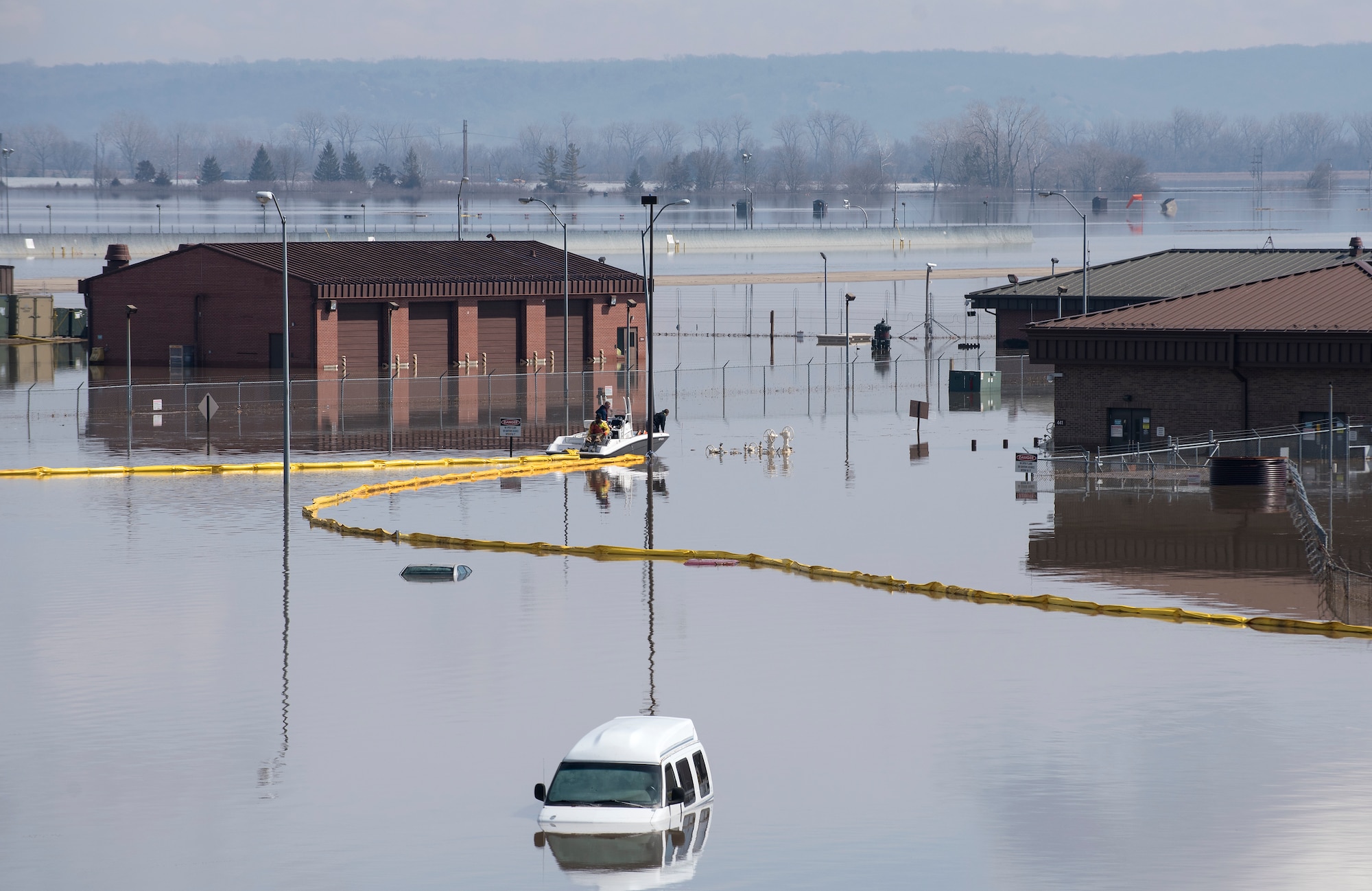 Environmental restoration employees deploy a containment boom from a boat March 18, 2019, on Offutt Air Force Base. One-third of the installation was flooded and the boom was a precautionary measure for possible fuel leaks.  (U.S. Air Force photo by Delanie Stafford)