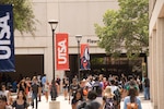 Students walking around the UTSA campus on a sunny school day.