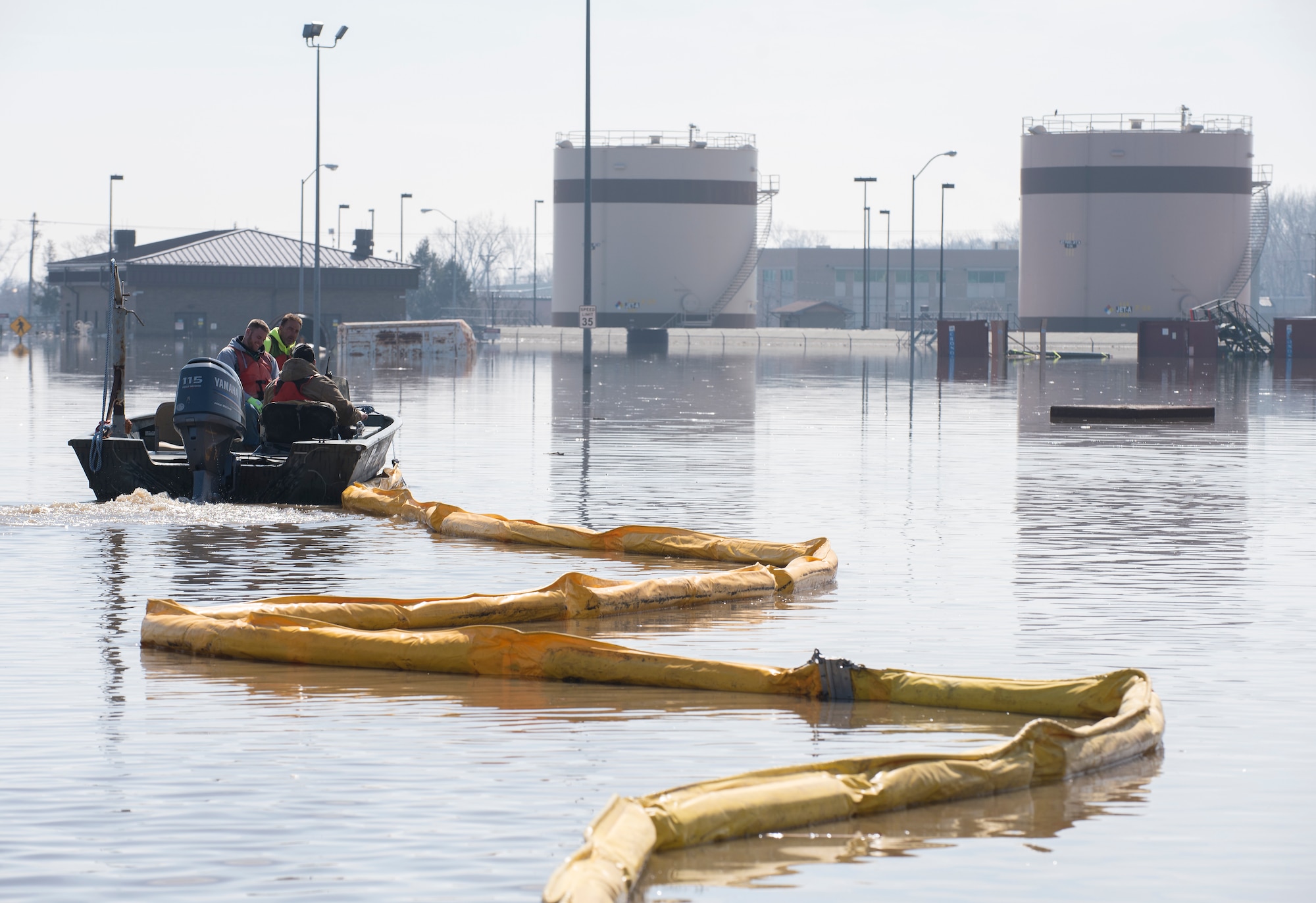 Environmental restoration employees deploy a containment boom from a boat March 18, 2019, on Offutt Air Force Base. One-third of the installation was flooded and the boom was a precautionary measure for possible fuel leaks.  (U.S. Air Force photo by Delanie Stafford)