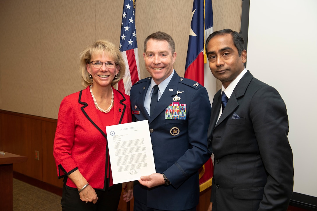 Col. Gregory Gagnon, Commander of NSA in Texas, presents The University of Texas in San Antonio with a letter announcing they have been named an NSA Featured School. With him are Kimberly Andrews Espy, Provost and Vice President for Academic Affairs and Bernard Arulanandam, Interim Vice President for Research, Development and Knowledge Enterprise.