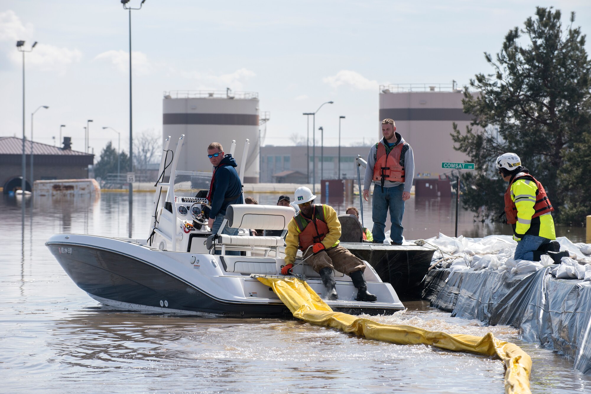 Environmental restoration employees deploy a containment boom from a boat March 18, 2019, on Offutt Air Force Base. One-third of the installation was flooded and the boom was a precautionary measure for possible fuel leaks.  (U.S. Air Force photo by Delanie Stafford)