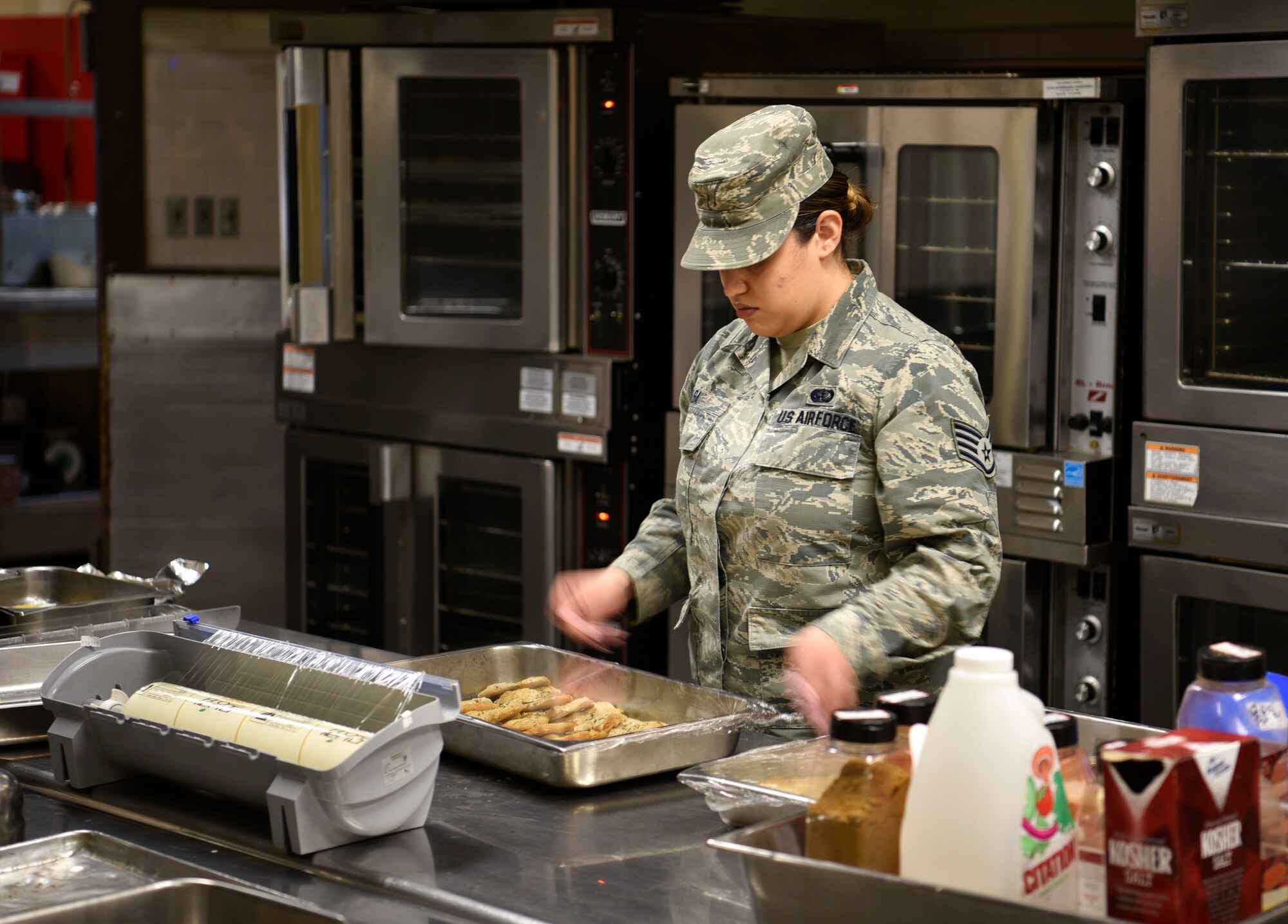U.S. Air Force Staff Sgt. Alyssa Alba, 8th Force Support Squadron Dining Facility quality assurance lead, prepares chicken for contingency operation meal service training at Kunsan Air Base, Republic of Korea, March 14, 2019. 8th FSS Airmen trained on the planning, preparing and serving of a hot meal during a contingency event. (U.S. Air Force photo by Tech. Sgt. Charles McNamara)