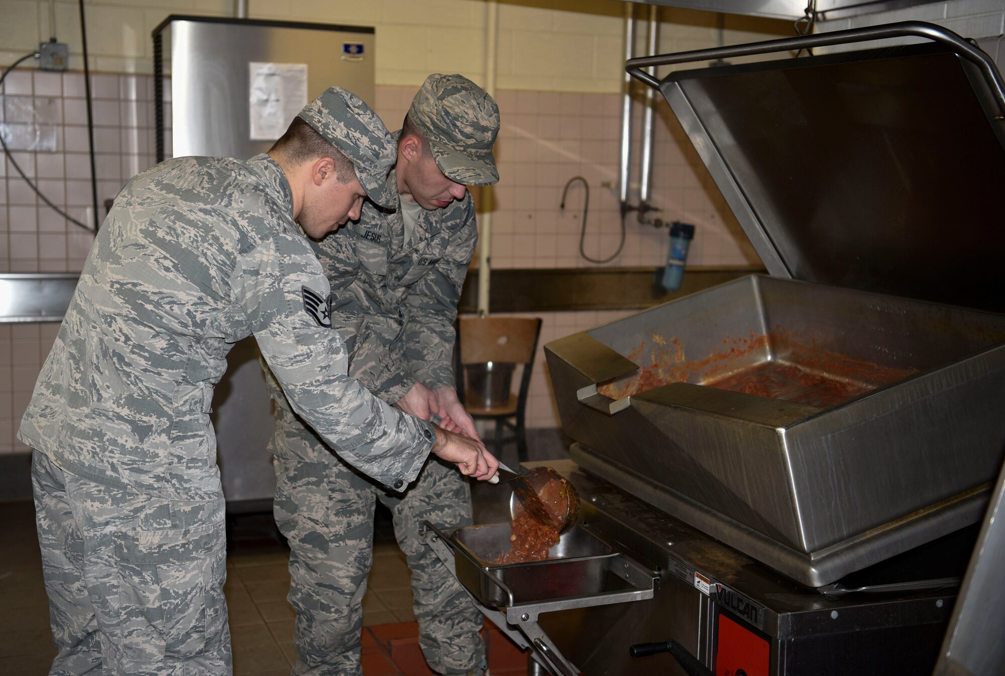 U.S. Air Force Staff Sgt. Tyler Roberts (left), 8th Force Support Squadron unit deployment manager, and Airman Jacob Jesus, 8th FSS fitness specialist, transfer beef fajita to a pan in preparation for contingency meal service training at Kunsan Air Base, Republic of Korea, March 14, 2019. 8th FSS Airmen trained on the planning, preparing and serving of a hot meal during a contingency event and provides a valuable opportunity for Airmen to practice food preparation usually performed by government contractors. (U.S. Air Force photo by Tech. Sgt. Charles McNamara)