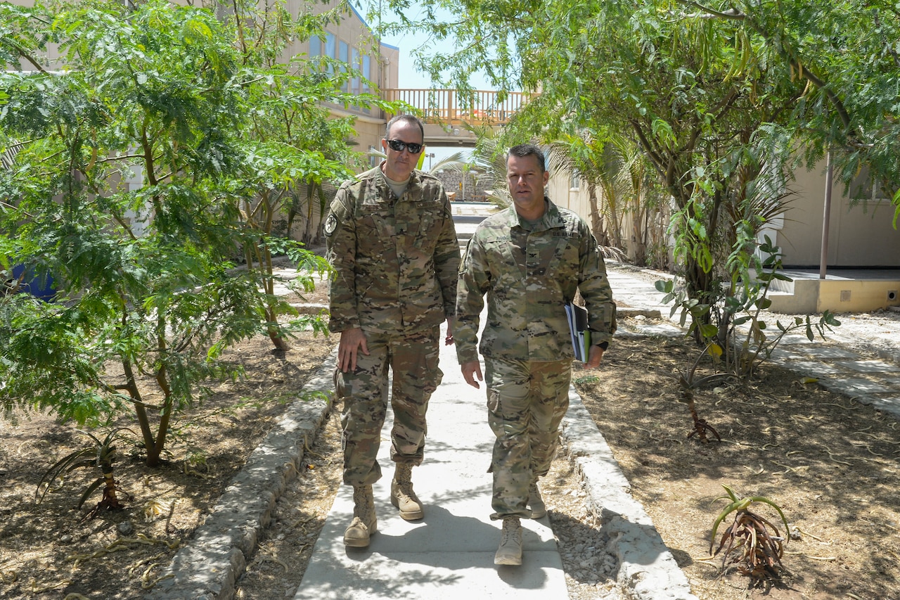 Two military officers talk while walking.