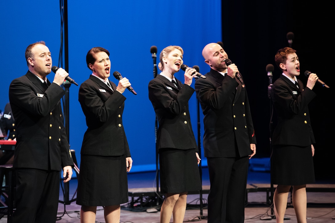 Service members sing in a chorus.