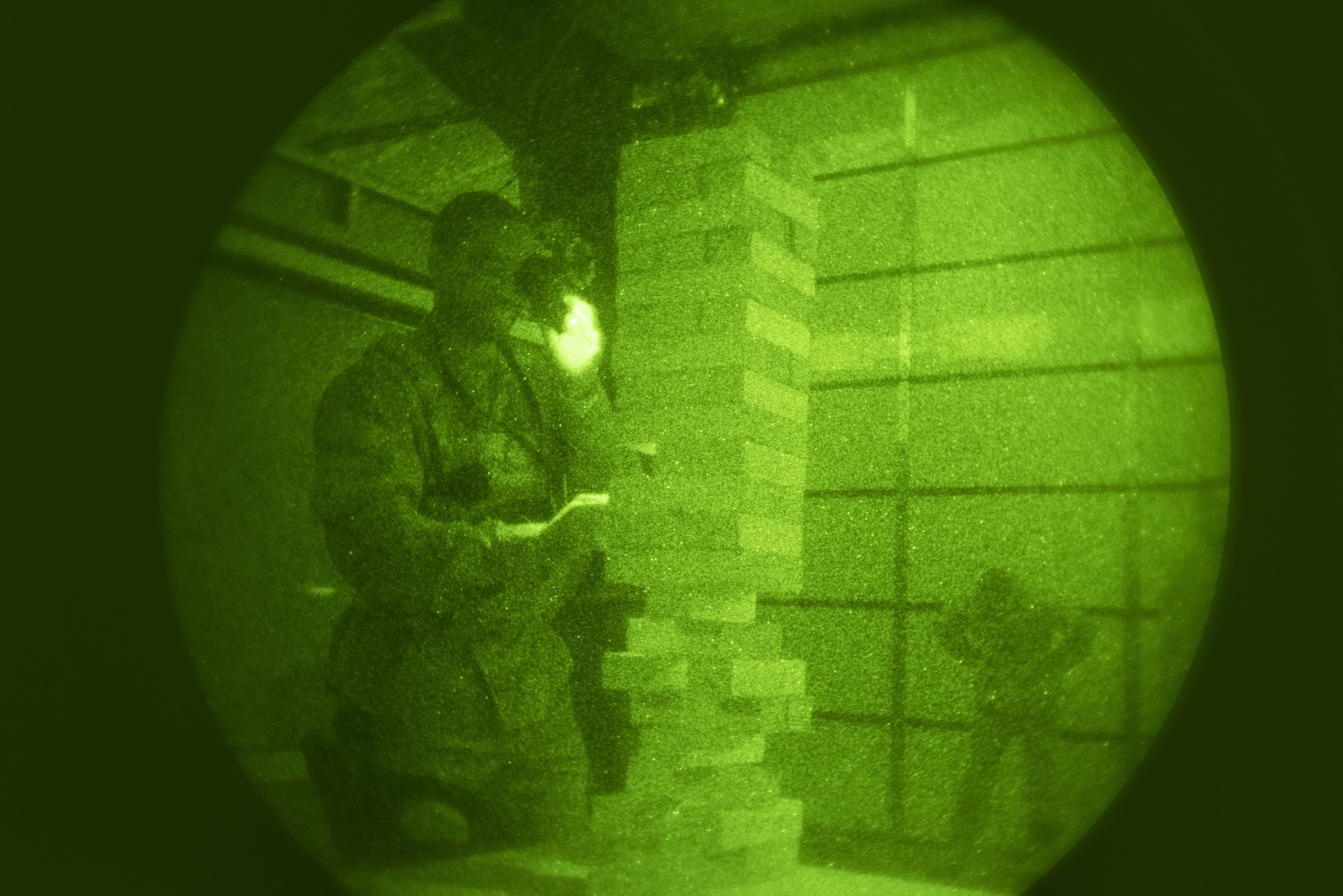 Tech. Sgt.  Jerald Harris, 50th Security Forces Squadron flight chief, challenges his motor skills by playing Jenga while using night vision goggles during a training session at the 50th SFS training facility at Schriever Air Force Base, Colorado, March 16, 2019. The 50th SFS training flight incorporated games as a way to increase training engagement and boost morale while meeting requirements.  (U.S. Air Force photo by Staff Sgt. Matthew Coleman-Foster)