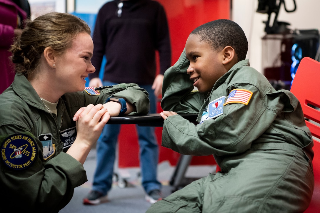 An airman speaks to a young child.