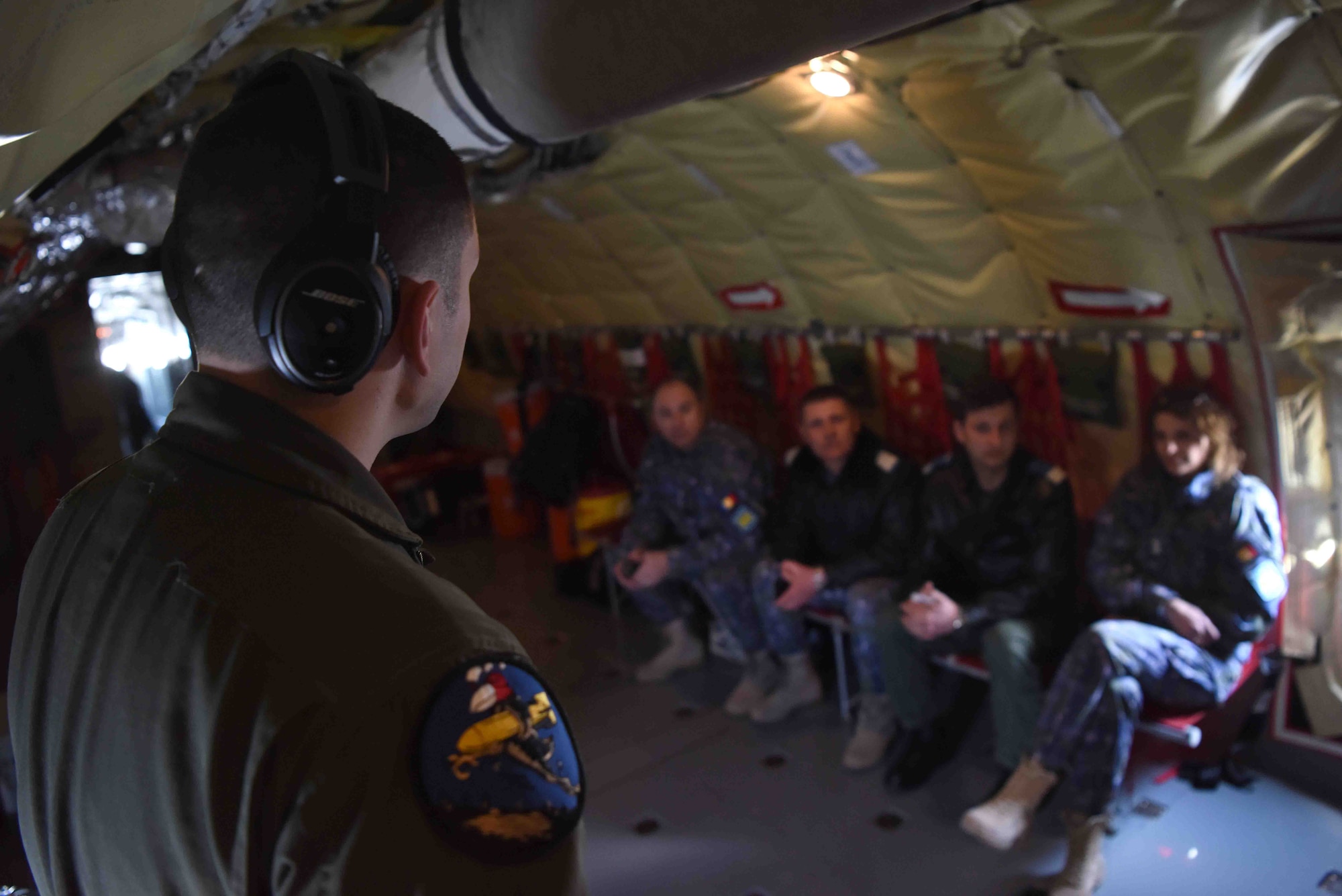 U.S. Air Force Senior Airman Corey Marion, 351st Air Refueling Squadron boom operator, goes over flight procedures with Romanian air force members aboard a KC-135 Stratotanker in Bucharest, Romania, March 13, 2019. The crew trained with Romanian air force F-16s over the skies of Romania, which enhanced regional capabilities to secure air sovereignty and promote peace and security through cooperation, collaboration, interoperability with NATO allies in the region. (U.S. Air Force photo by Airman 1st Class Brandon Esau)
