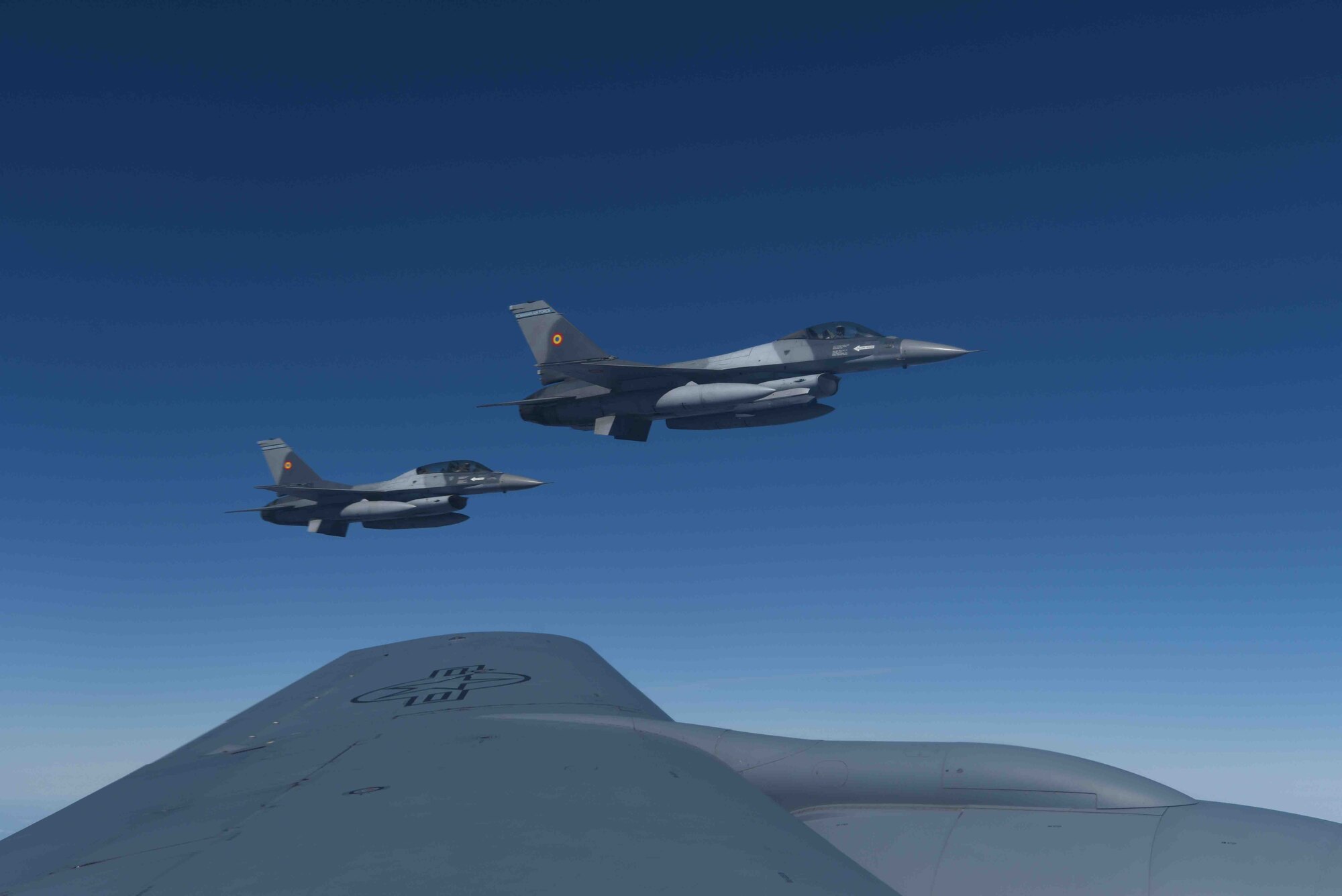 Romanian air force F-16s fly in formation prior to receiving fuel from a 100th Air Refueling Wing KC-135 Stratotanker from RAF Mildenhall, England, during aerial refueling training over the skies of Romania, March 13, 2019. The training was an example of U.S. and NATO allies sharing a commitment to promote peace and stability through developing their relationship and communication process. (U.S. Air Force photo by Airman 1st Class Brandon Esau)