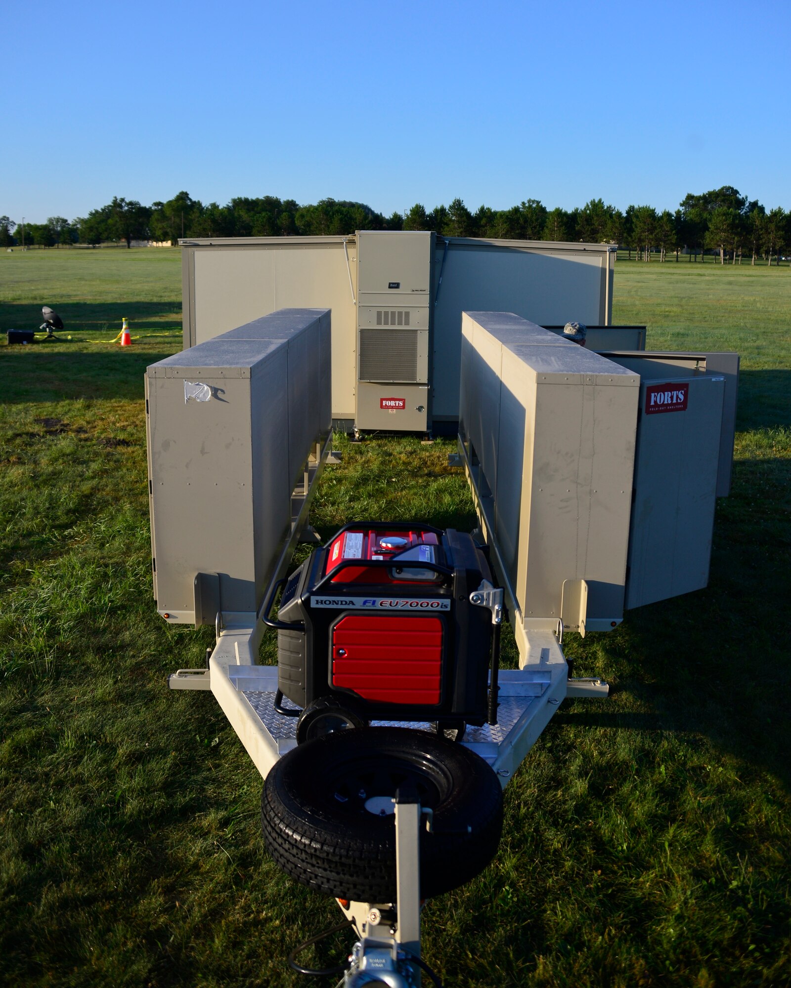 Members of the Joint Chaplain Corps from the Army, Air Force, and Navy fold up the Tactical Field Religious Support Kit (TFRSK) at Volk Field Combat Readiness Training Center, Wis., July 23, 2015. The TFRSK, which provides a climate controlled space for members to use to decompress or participate in religious services, was on display for the first time during PATRIOT Exercise 2015. (U.S. Air National Guard photo by Tech. Sgt. Amy M. Lovgren/Released)