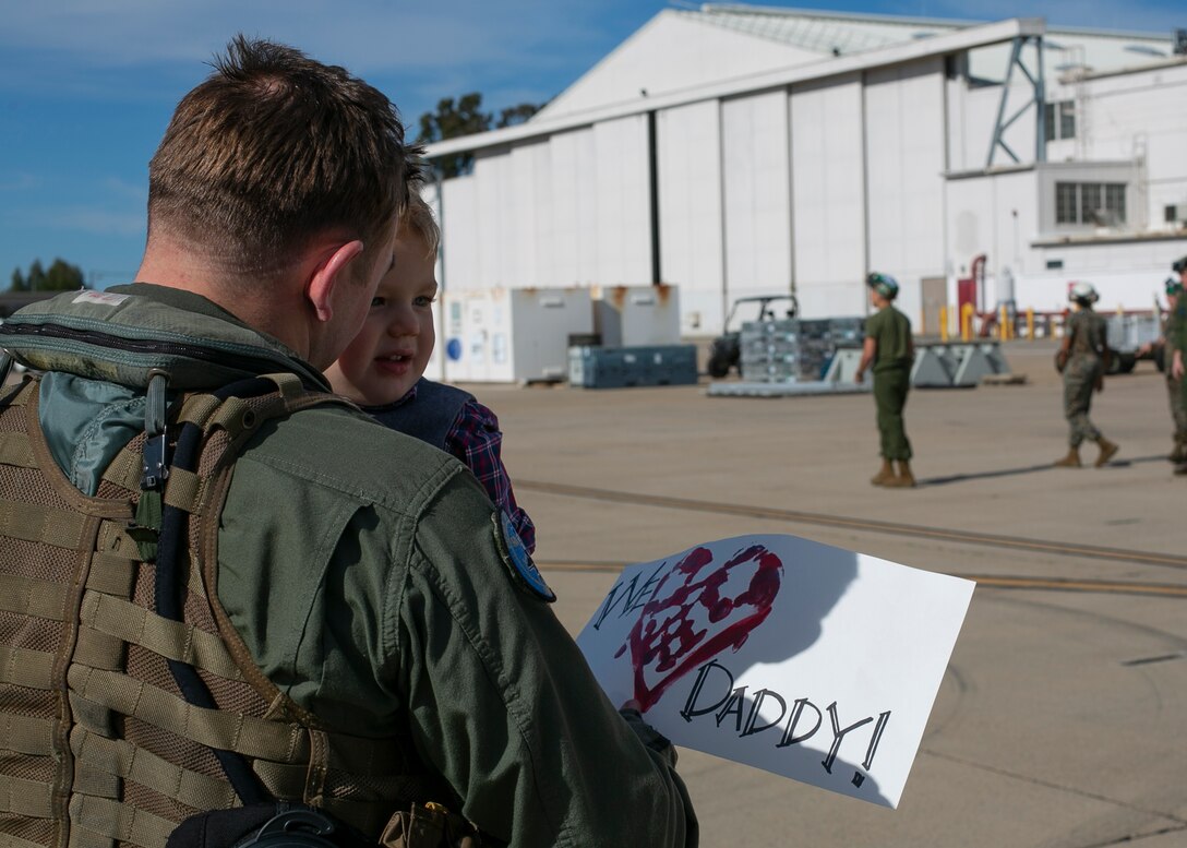 U.S. Marine Corps Maj. Andrew Mettler, an F/A-18 pilot with Marine Fighter Attack Squadron 225, Marine Aircraft Group 11, 3rd Marine Aircraft Wing, holds his son at Marine Corps Air Station Miramar, Calif., March 15, following a six-month Unit Deployment Program in Japan. Marines and Sailors flew, fixed, and fought alongside foreign forces throughout Guam, South Korea, and Japan as part of America’s Expeditionary Force in Readiness. (U.S. Marine Corps photo by Lance Cpl. Julian Elliott-Drouin)