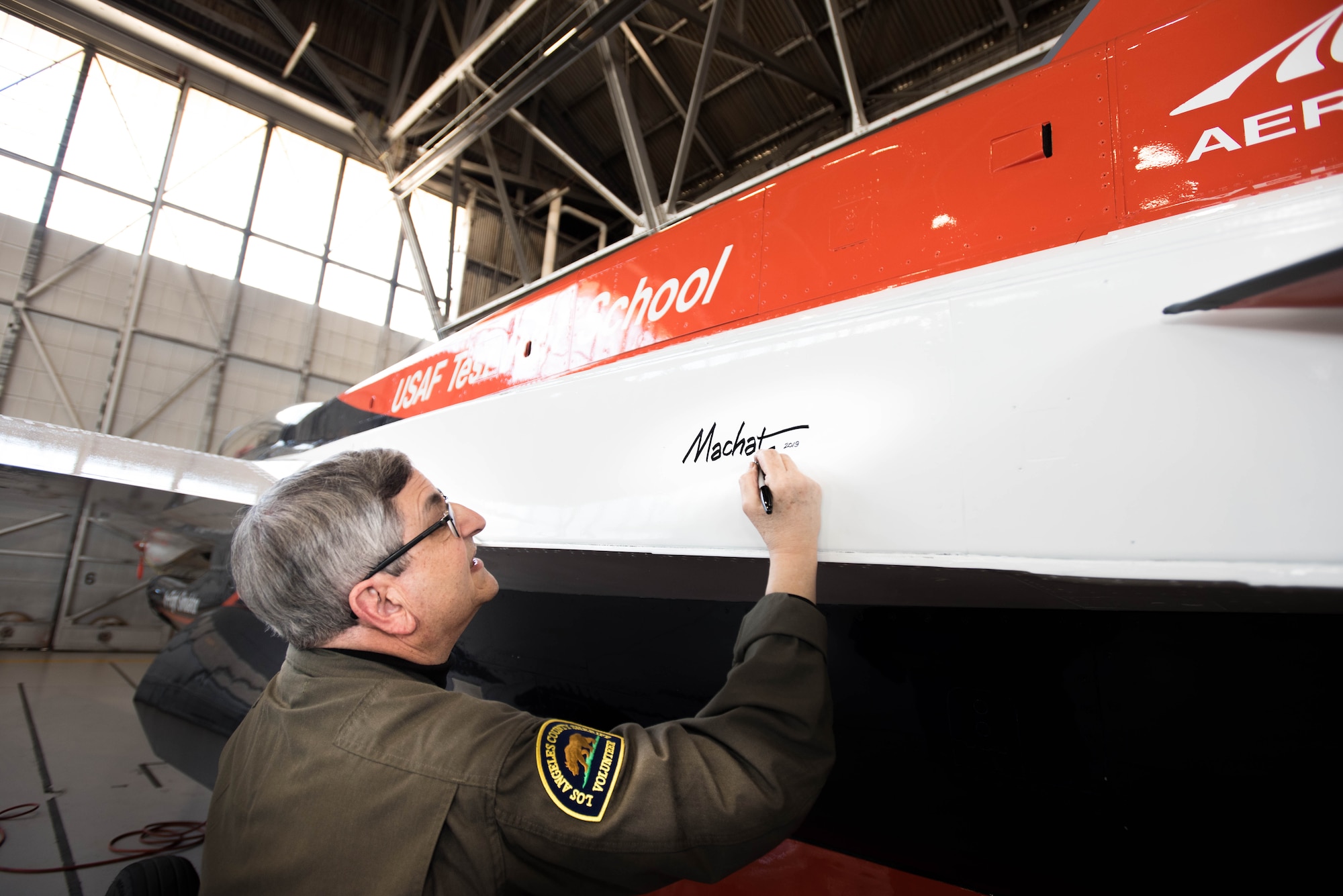 Renowned aviation artist Mike Machat officially endorsed his latest work for the U.S. Air Force Test Pilot School March 7 when he applied his signature to the school’s NF-16D VISTA in-flight simulator. (U.S. Air Force photo by Joe Jones)