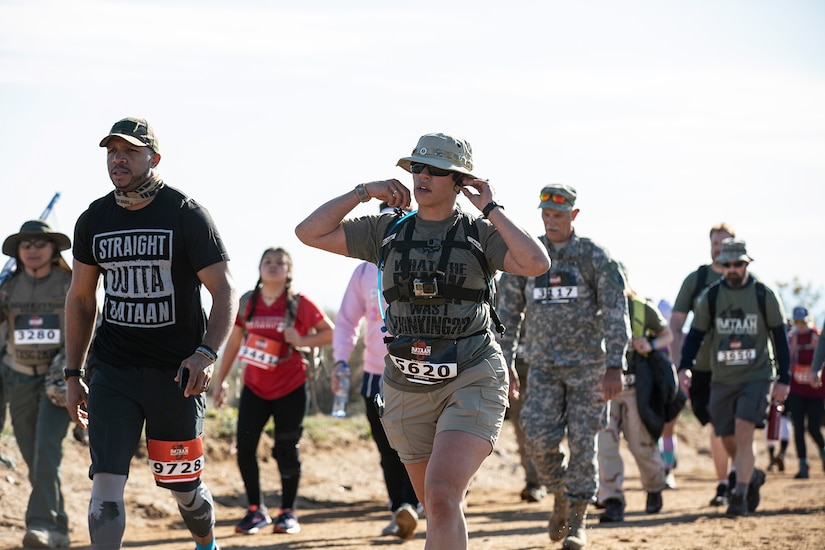 A woman marches along rough terrain.