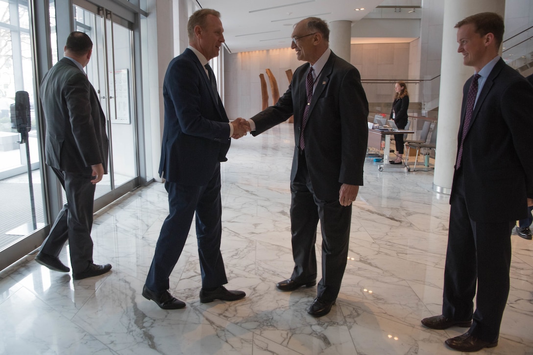 Acting Defense Secretary Patrick M. Shanahan shakes hands with a man.