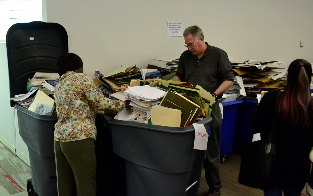 DLA Troop Support Construction and Equipment supply chain employees secure trash in bins during the spring clean-up event in Building 3 March 20, 2019 in Philadelphia. The employees participated in the housekeeping component of the VPP program, an OSHA led initiative, that encourages cooperative efforts between management, employees and unions to reduce mishaps, pest and improve workplace safety. (Photo by Janeen Hayes).