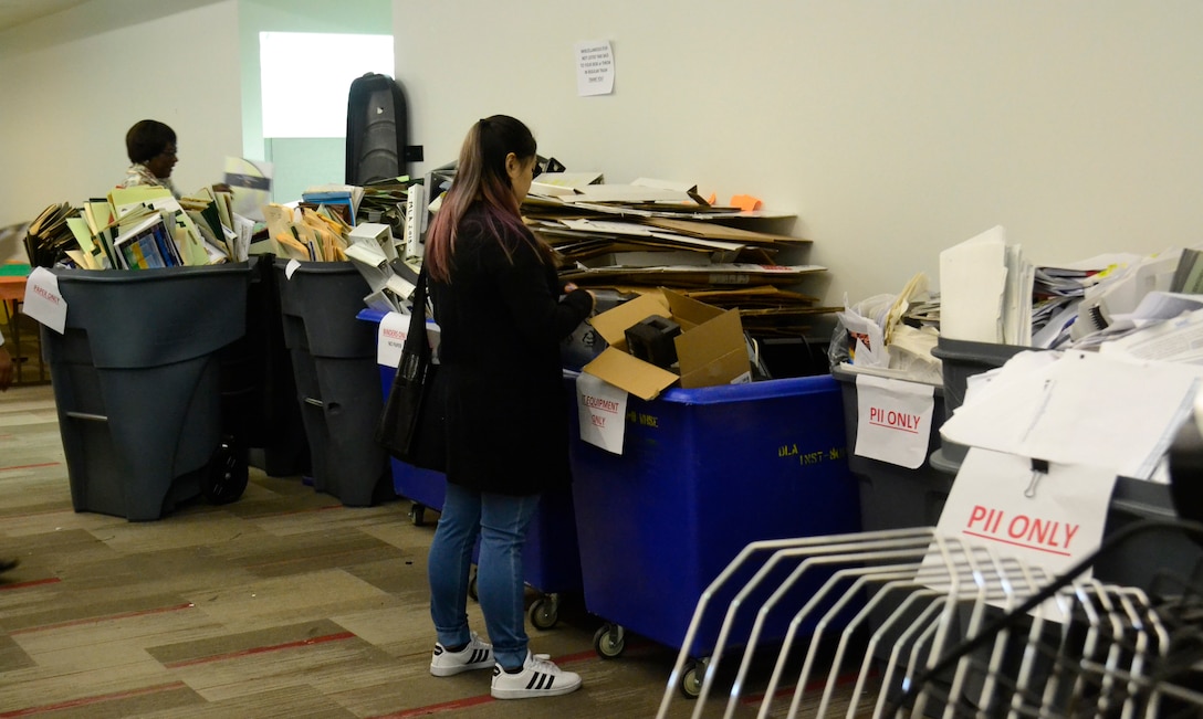 DLA Troop Support Construction and Equipment supply chain employees secure trash in bins during the spring clean-up event in Building 3 March 20, 2019 in Philadelphia. The employees participated in the housekeeping component of the VPP program, an OSHA led initiative, that encourages cooperative efforts between management, employees and unions to reduce mishaps, pest and improve workplace safety. (Photo by Janeen Hayes).