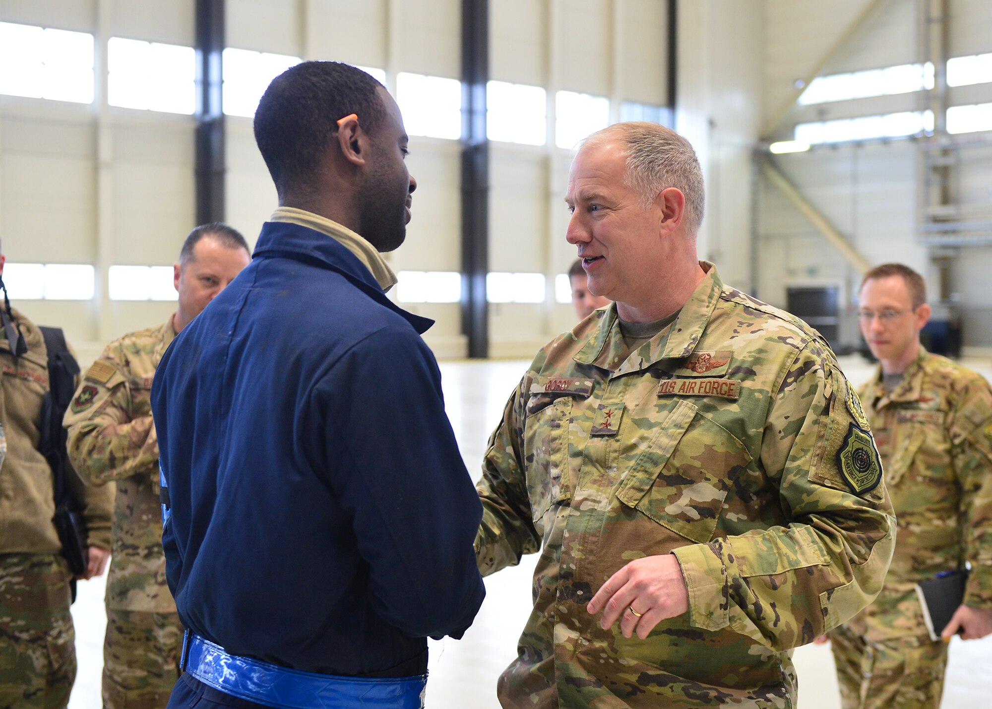 U.S. Air Force Maj. Gen. John Gordy, U.S. Air Force Expeditionary Center commander, hands a coin to Staff Sgt. Reuben Bowers, 721 Aircraft Maintenance Squadron C-17 Globemaster crew chief craftsman, for outstanding performance in his unit at Ramstein Air Base, Germany, March 14, 2019.