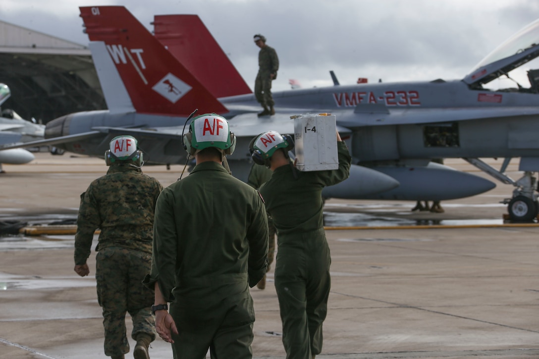 Marines with Marine Fighter Attack Squadron (VMFA) 232, Marine Aircraft Group (MAG) 11, 3rd Marine Aircraft Wing (MAW), head toward the aircraft with their toolbox to conduct maintenance prior to takeoff at Marine Corps Air Station (MCAS) Miramar, Calif., March 8. The Red Devils are in the Unit Deployment Program rotation and are preparing to depart for MCAS Iwakuni, Japan. Their mission during the six-month deployment is to strengthen relationships, modernize U.S. alliances and support joint security in the Indo-Pacific region. (U.S. Marine Corps photo by Lance Cpl. Levi J. Guerra)