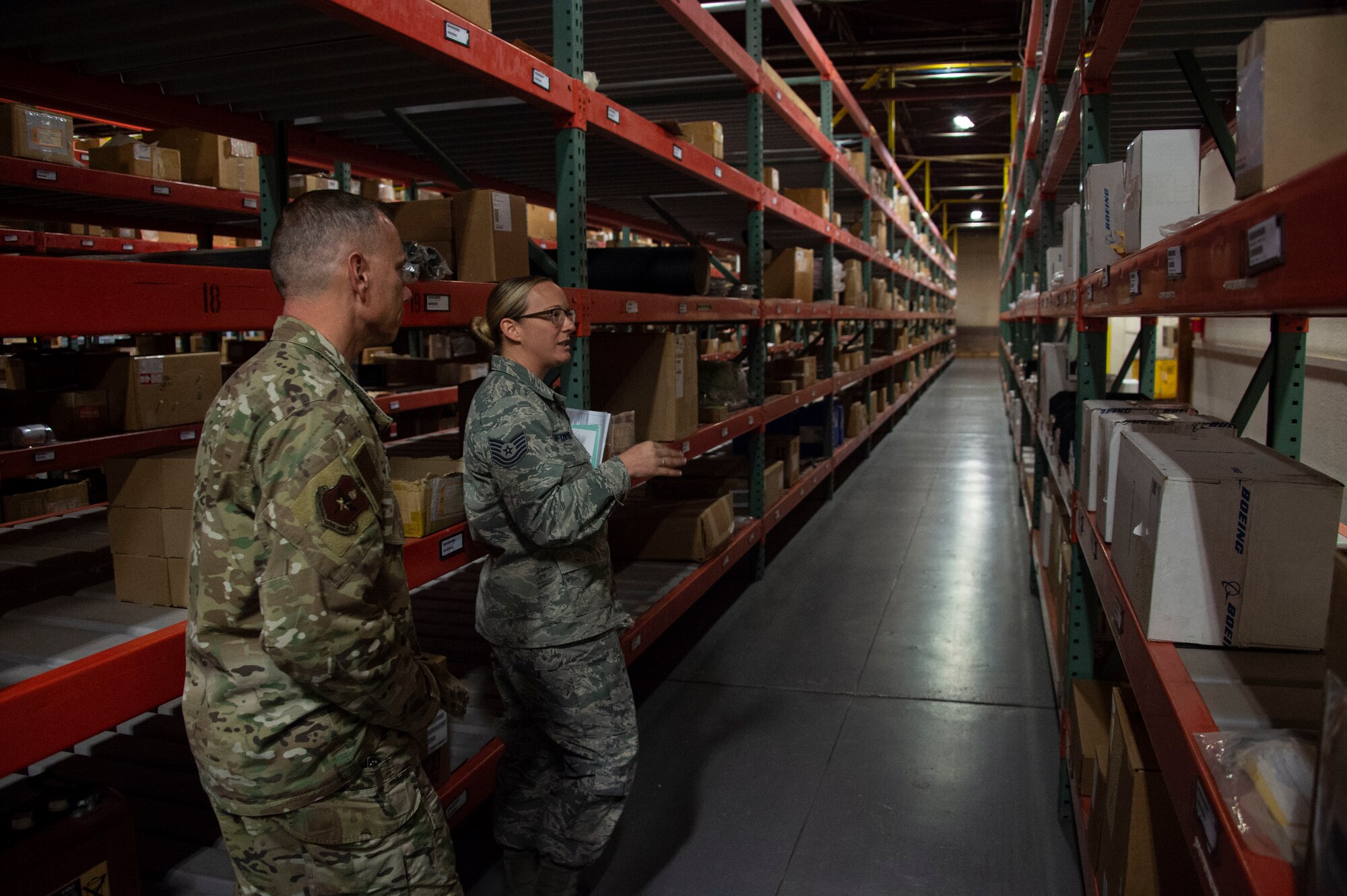 U.S. Air Force Tech Sgt. Nicole Finnegan, 97th Logistics Readiness Squadron NCO in charge of storage and issue, showcases the supply facility to Chief Master Sgt. Erik Thompson, command chief of the 19th Air Force