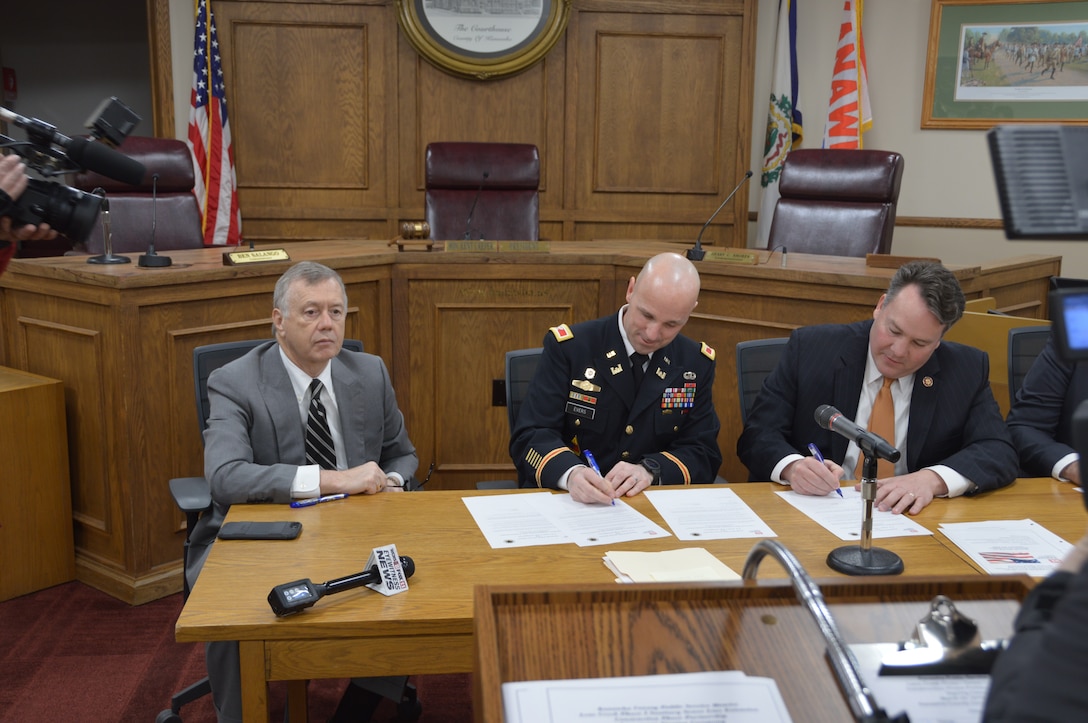 Colonel Jason Evers and Congressman Alex Mooney sign the Lens Creek Partnership Agreement as Kent Carper, President, Kanawha County Commission looks on.