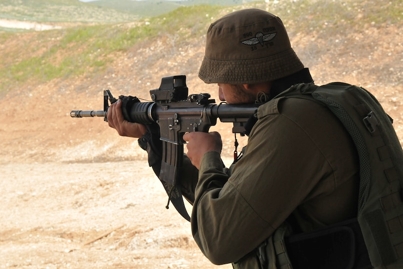 An Israeli soldier fires a rifle.