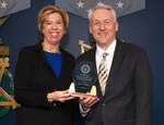 two people in pose with award