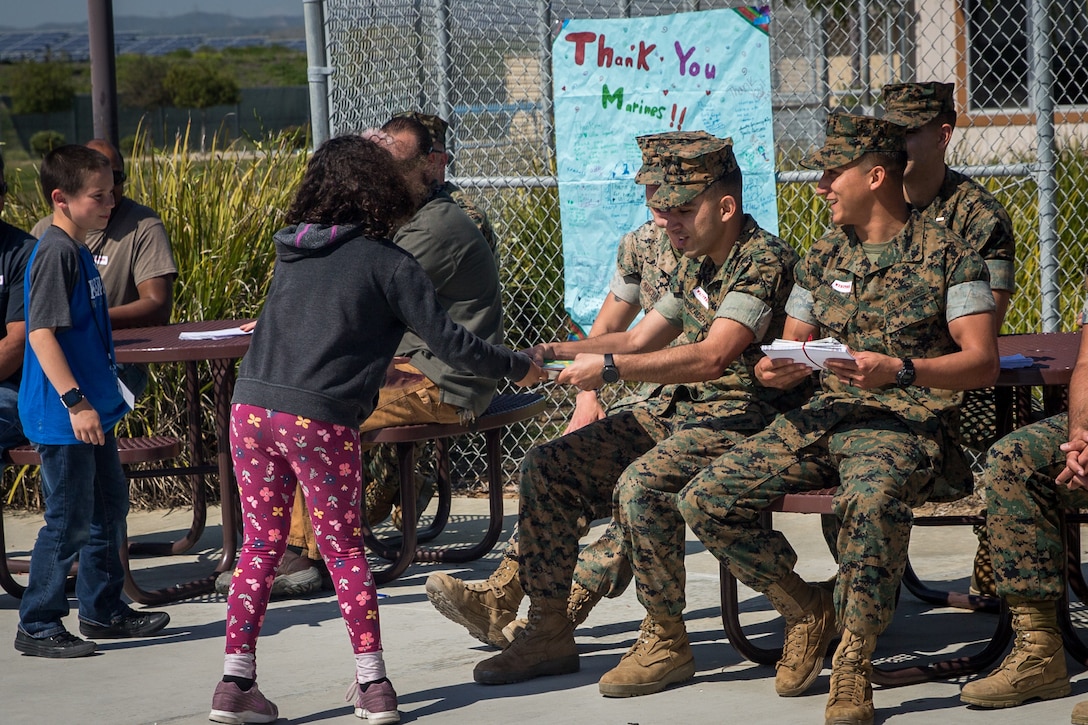 U.S. Marines with Bridge Company, 7th Engineer Support Battalion, 1st Marine Logistics Group, and contractors with Facilities Maintenance Department, Marine Corps Installations West, Marine Corps Base Camp Pendleton, receive “thank you” letters from students at Santa Margarita Elementary School on MCB Camp Pendleton, California, March 18, 2019. The students of the elementary school wrote personal “thank you” letters to the Marines and contractors for building a bridge over and repairing a sinkhole in Carnes Road that resulted in the evacuation and temporary closing of the school on Feb. 4. The sinkhole was caused by erosion resulting from persistent heavy rain storms that swept through Southern California.