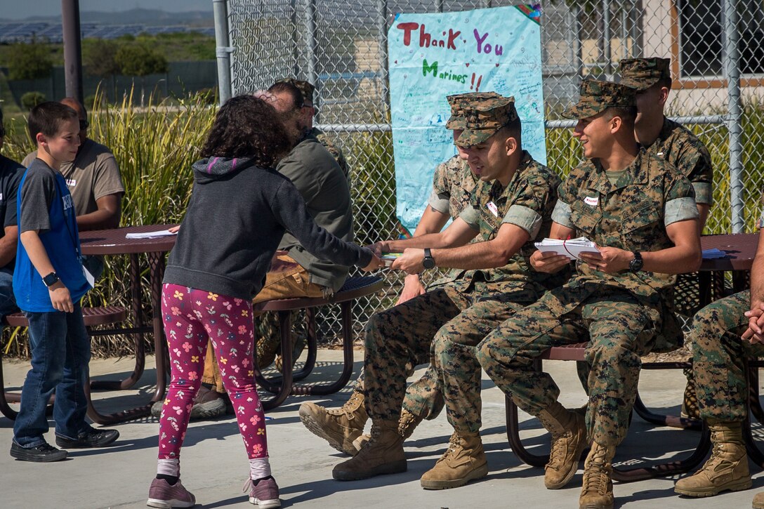 U.S. Marines with Bridge Company, 7th Engineer Support Battalion, 1st Marine Logistics Group, and contractors with Facilities Maintenance Department, Marine Corps Installations West, Marine Corps Base Camp Pendleton, receive “thank you” letters from students at Santa Margarita Elementary School on MCB Camp Pendleton, California, March 18, 2019. The students of the elementary school wrote personal “thank you” letters to the Marines and contractors for building a bridge over and repairing a sinkhole in Carnes Road that resulted in the evacuation and temporary closing of the school on Feb. 4. The sinkhole was caused by erosion resulting from persistent heavy rain storms that swept through Southern California.