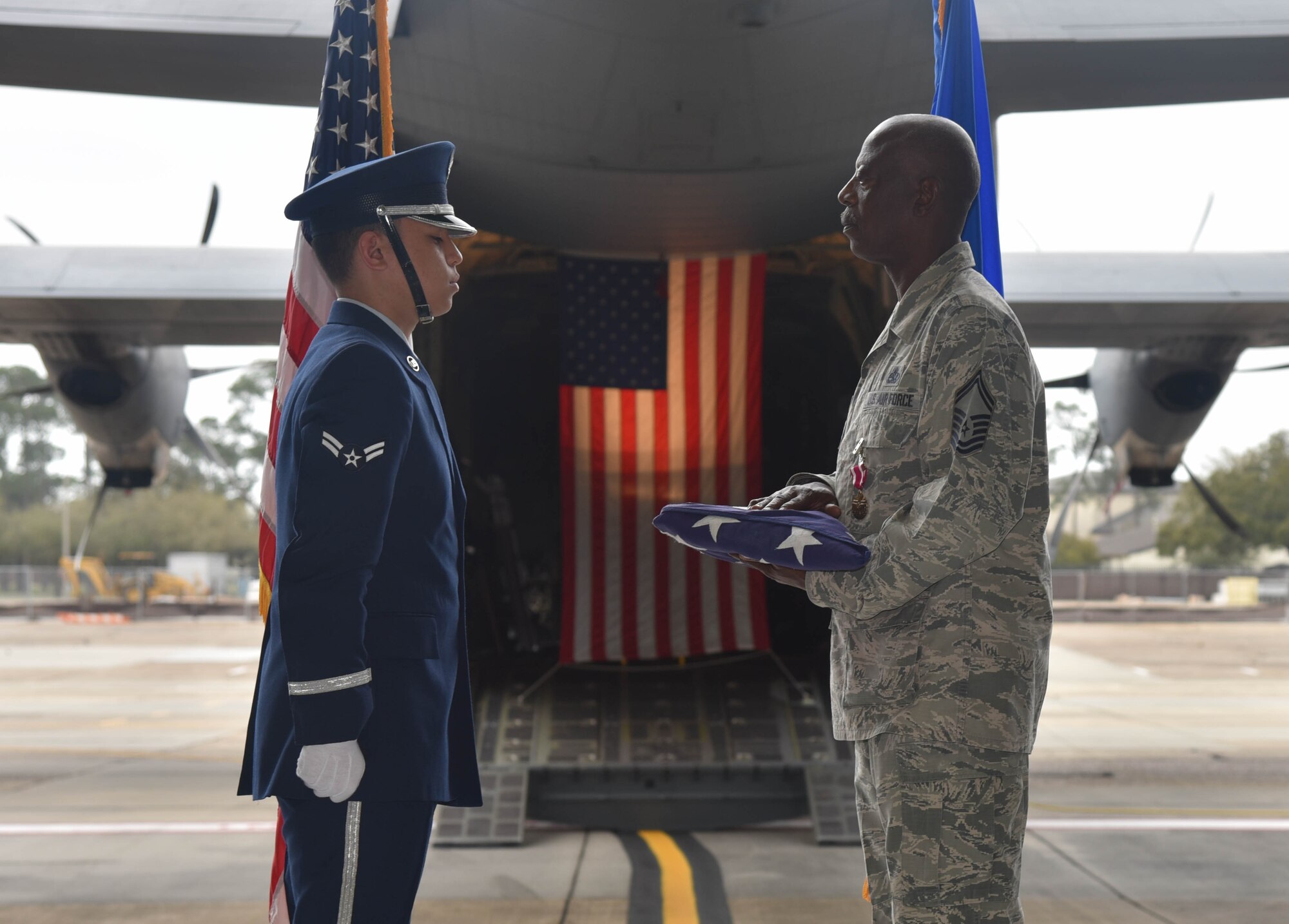 Senior Master Sgt. Charles Moore, 803rd Aircraft Maintenance Squadron production superintendent, accepts folded U.S. flag from an Honor Guard Airman during Moore's retirement ceremony, March 8, 2019.  Moore offiicially retires from his duties after serving 33-years in the Air Force Reserve, April 1, 2019. (U.S. Air Force photo by Tech. Sgt. Michael Farrar)