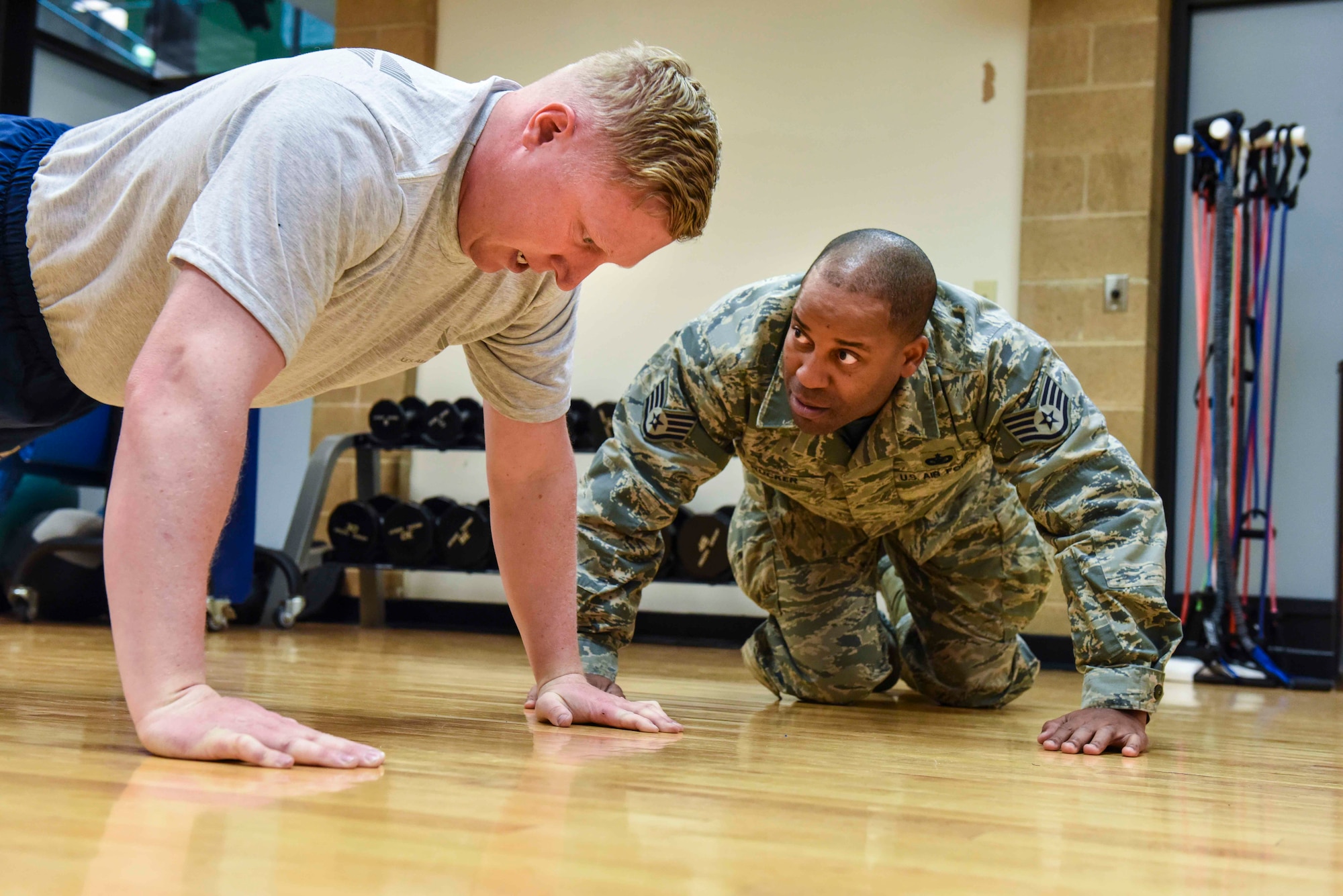 Staff Sgt. Derek Rucker, an air transport apprentice in the 67th Aerial Port Squadron, motivates an Airman to perform a few more repetitions during the pushup portion of the Air Force physical fitness test March 2, 2019, at the Warrior Fitness Center on Hill Air Force Base, Utah