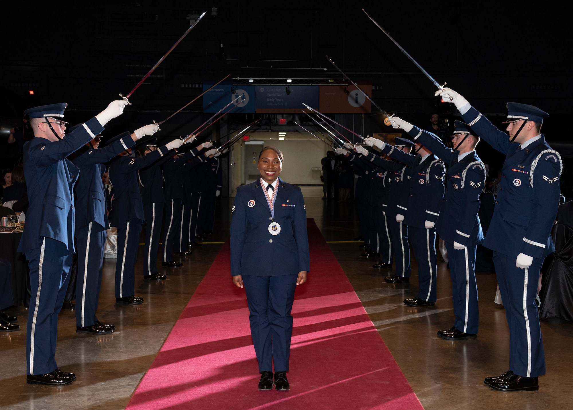 Senior Airman Mutia Graham, Air Force Test Center, walks through a formation of sabers during Air Force Materiel Command's Annual Excellence Awards Banquet March 6, 2019, at Wright-Patterson Air Force Base, Ohio. (U.S. Air Force photo by Michelle Gigante)