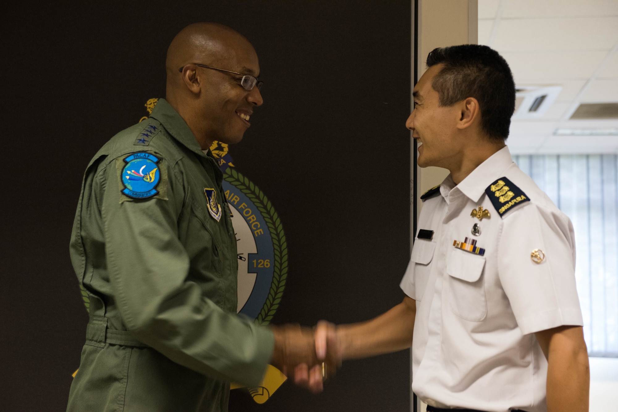 U.S. Air Force Gen. CQ Brown, Jr., Pacific Air Forces commander, shakes hands with Singapore Air Force Col. Sherman Ong, Command Helicopter Group, after a visit to Sembawang Air Base, Singapore, March 19, 2019.