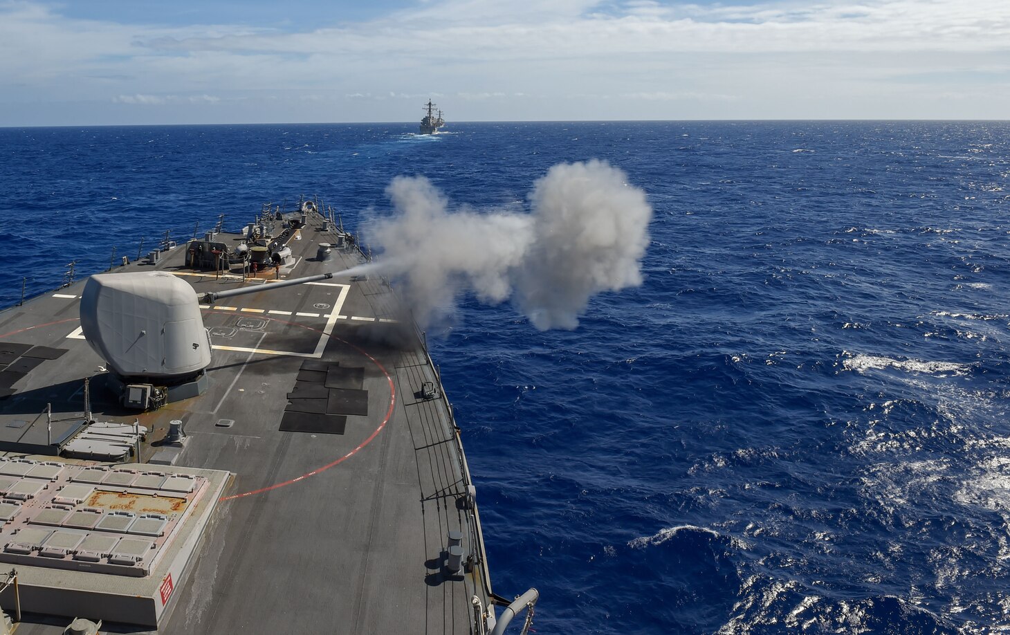 PHILIPPINE SEA (Mar. 14, 2019) The Arleigh Burke-class guided-missile destroyer USS Milius (DDG 69) fires its mark 45 5 inch gun during training with other U.S. Navy warships. U.S. Navy warships train together to increase the tactical proficiency, lethality and interoperability of participating units in an Era of Great Power Competition.