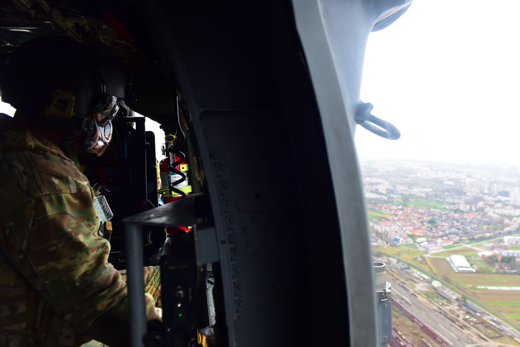 A 56th Rescue Squadron special mission aviator, stationed at Aviano Air Base, Italy, surveys a landing zone during a Non-combatant Evacuation Operation exercise near Zagreb, Croatia, March 18, 2019. Special mission aviators survey landing zones and update aircraft crew members on rescue operations. (U.S. Air Force photo by Senior Airman Kevin Sommer Giron)