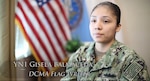 Woman in Navy uniform sits in front of camera.