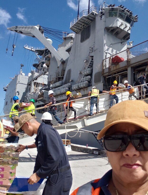 DLA Troop Support Indo-Pacific forward logistics specialist Bobbie Delgado, standing in the right foreground, observes the loading of more than $410,000 in subsistence supplies March 14, 2019 in Guam.
