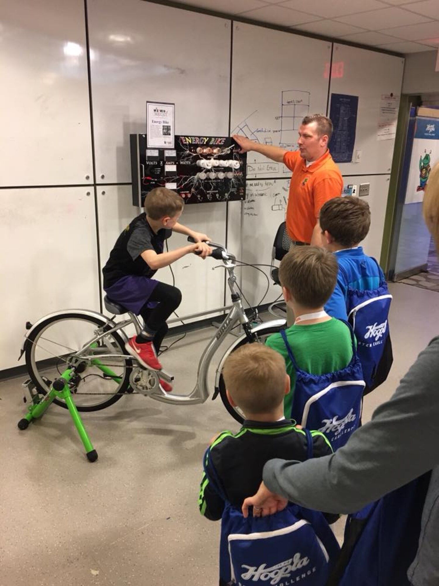 K-12 STEM team lead Dann Andrews (right) from the Wright-Patterson Air Force Base Educational Outreach Office explains to attendees how the energy bike works at the Hoopla STEM challenge on March 17 at Chaminade Julienne High School in Dayton, Ohio.  The STEM challenge event was part of the Dayton Big Hoopla. (Courtesy photo)