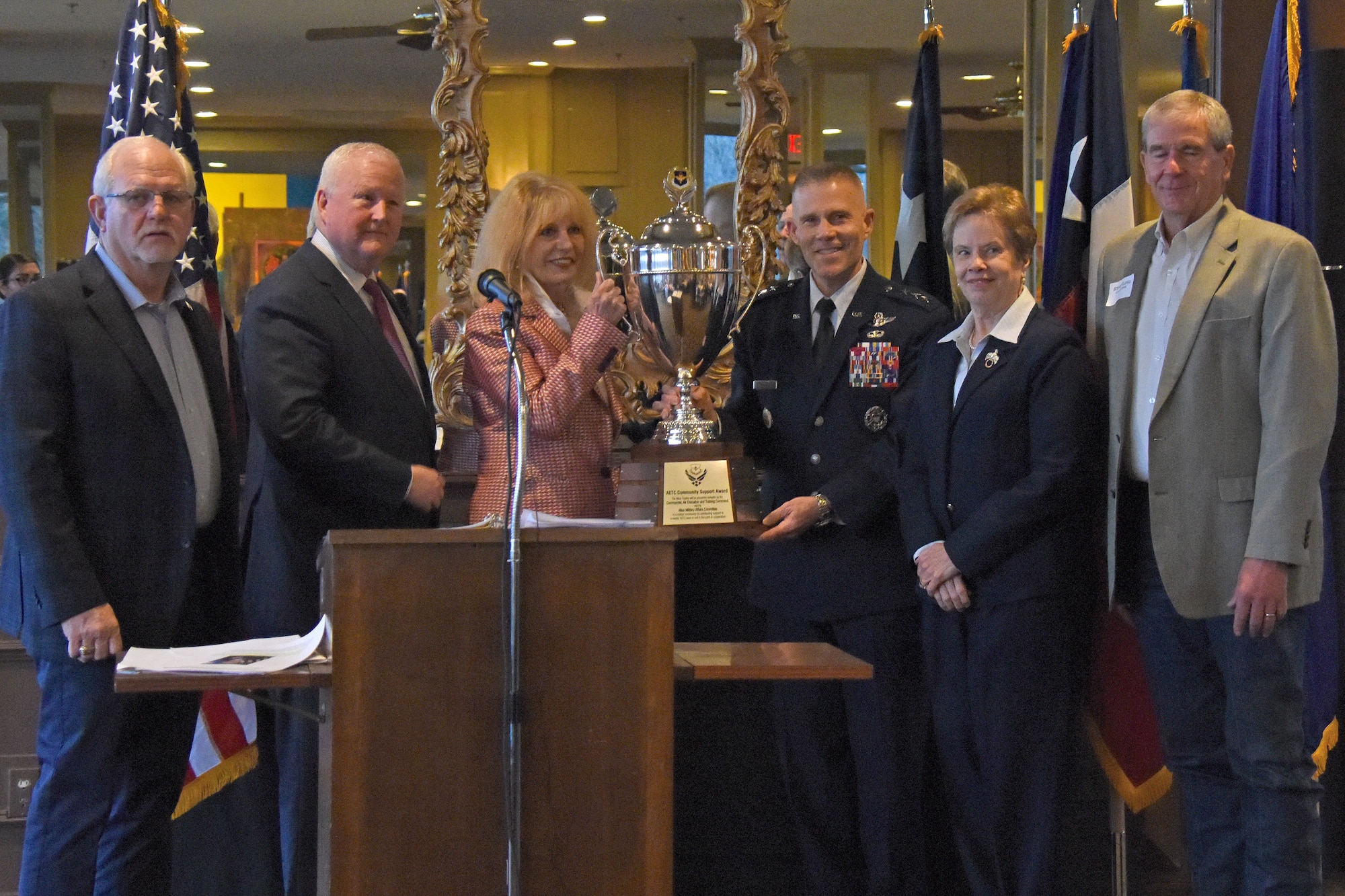 San Angelo Mayor Brenda Gunter, joined by San Angelo civic leaders, receives the Air Education and Training Command Altus Trophy from U.S. Air Force Lt. Gen. Steve Kwast, commander of AETC, at the dinner for San Angelo and Goofellow leaders at the Riverview Restaurant in San Angelo, Texas, March 20, 2019. The Altus Trophy is presented annually to the community with the strongest ties to their AETC base. (U.S. Air Force photo by Senior Airman Seraiah Hines/Released)