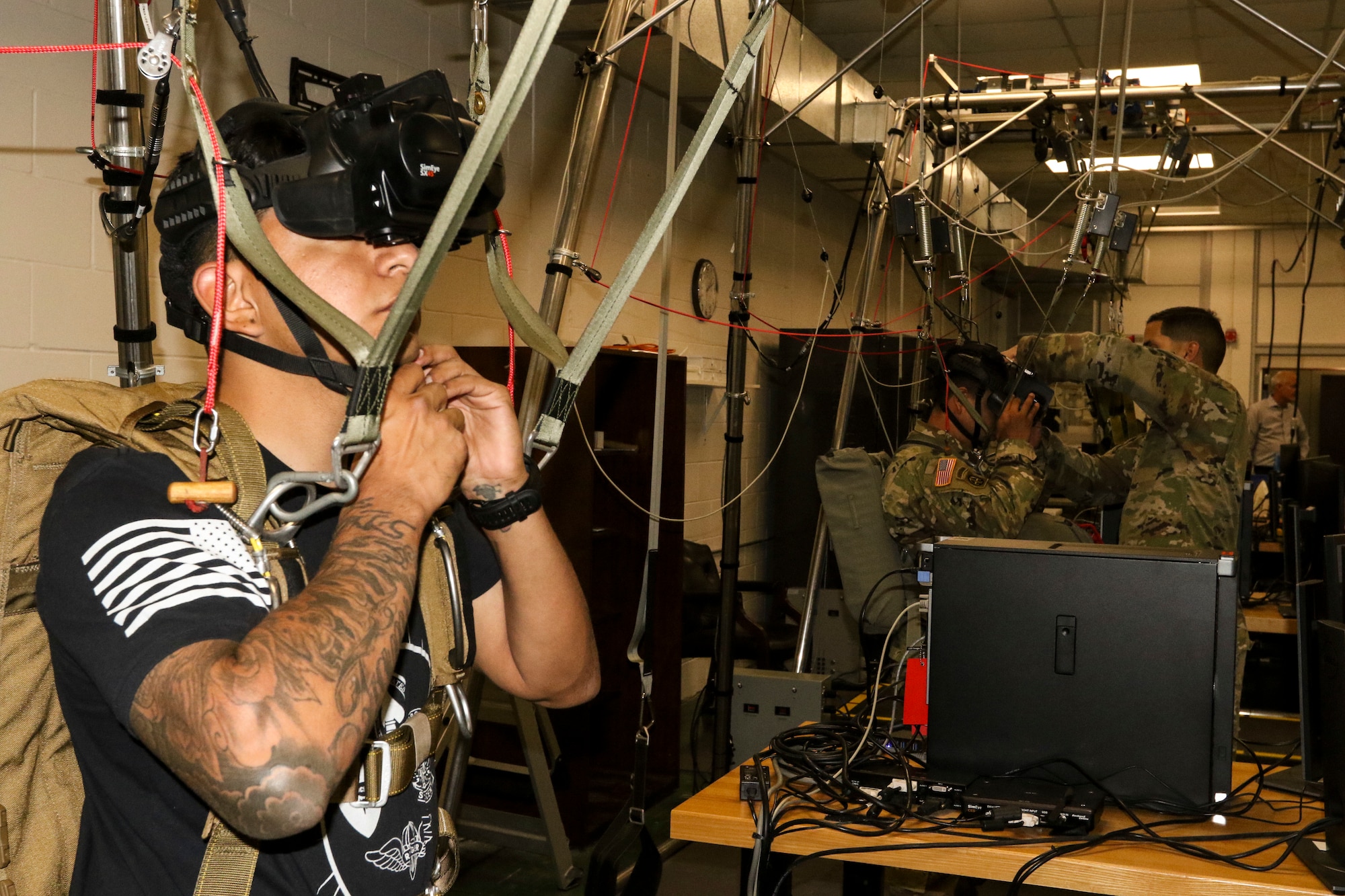 A paratrooper prepares for a virtual reality jump training on the new Parachute Simulator (PARASIM) 7 at the Joint Riggers Facility, MacDill Air Force Base, Tampa, Fla., Feb. 21, 2019. The PARASIM 7 recreates the experience of a real parachute jump from the head-mounted 3D virtual reality display to the suspension harness that detects jumper inputs. The physics-based parachute simulation technology recreates the conditions of a live jump using real-world scenes, malfunctions, wind profiles, various weather conditions and a full library of terrain types. (U.S. Army photo by Staff Sgt. Steven Colvin)