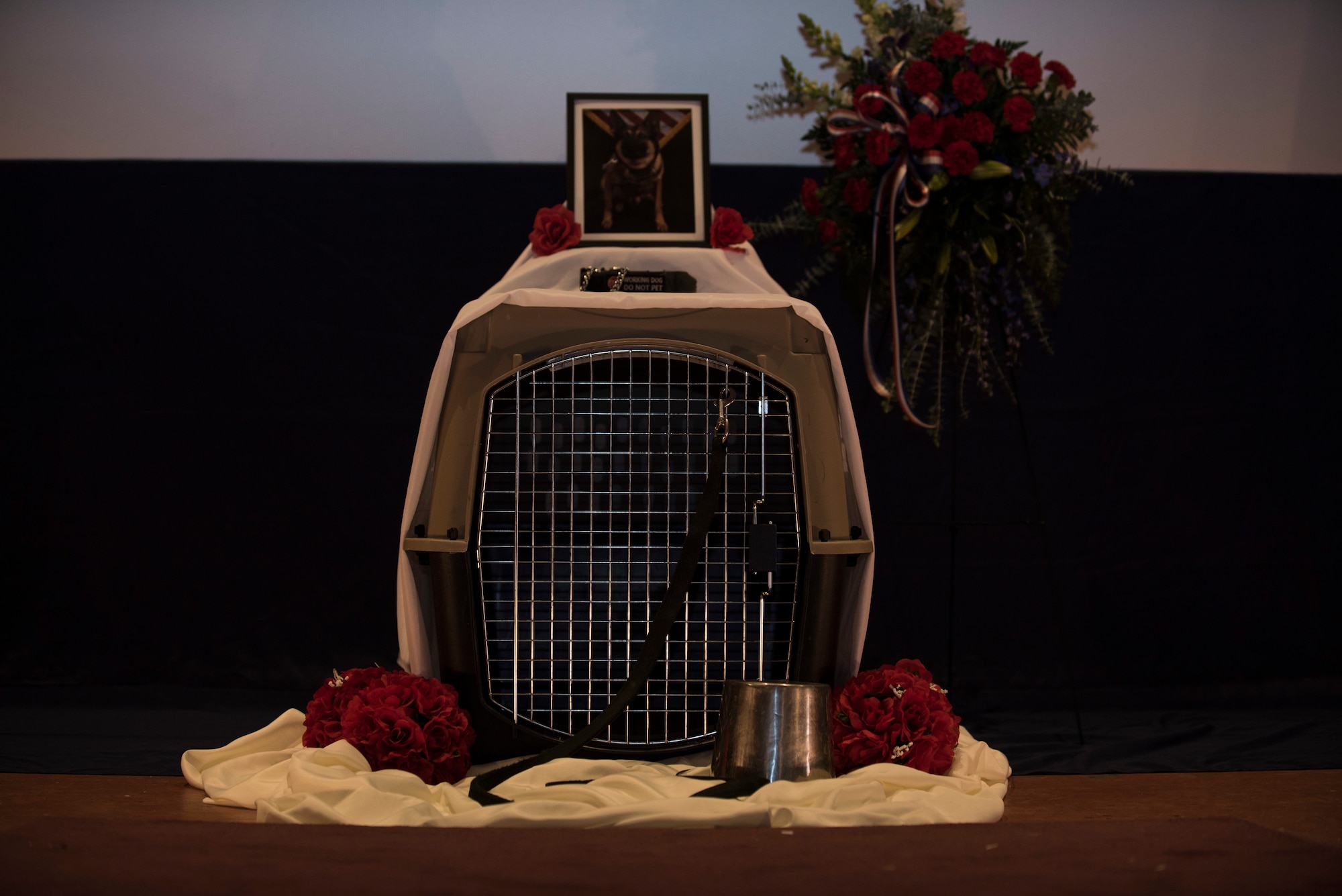 A memorial was held for Military Working Dog Nemo March 22, 2019, at F.E. Warren Air Force Base, Wyo., and on top of the stage sat his empty kennel with a bowl and leash. MWD Nemo was diagnosed with kidney cancer and was eventually laid to rest due to the stark prognosis. (U.S. Air Force photo by Senior Airman Abbigayle Williams)