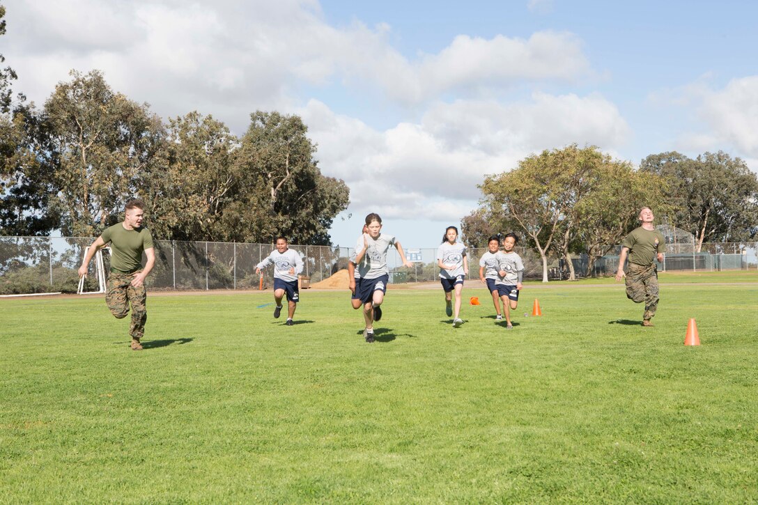 Marines from Marine Corps Air Station Miramar race to the finish line with De Portola Middle School students during the 9th annual Marine Corps Fitness Challenge at the De Portola Middle School in San Diego, Calif., March 22, 2019. During the challenge, MCAS Miramar Marines led students through four different physical training courses during their physical education periods to give the students a better outlook on physical fitness. (U.S. Marine Corps photo by Lance Cpl. Raynaldo Ramos)