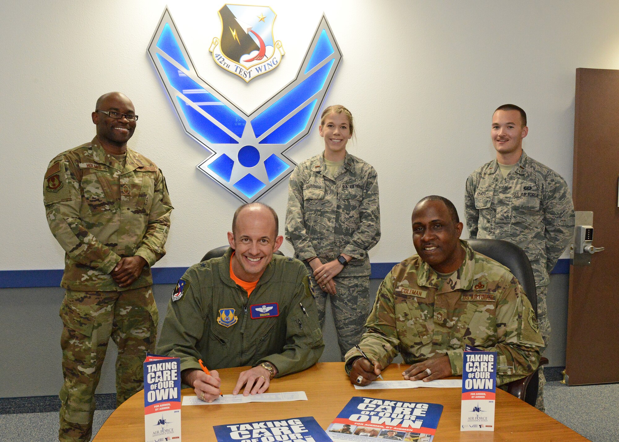 Brig. Gen. E. John Teichert, 412th Test Wing commander, and Chief Master Sgt. James Coleman, 412th TW acting command chief, pose for a photo while filling out their Air Force Assistance Fund donation forms March 22. Standing in the back, from left to right are this year's AFAF managers: Senior Master Sgt. Brian Holmes, 2nd Lt. Morgan Mavroudis and 2nd Lt. Evan Amato. (U.S. Air Force photo by Kenji Thuloweit)