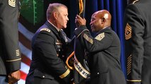 Command Sgt. Maj. Finis A. Dodson receives the U.S. Army Space and Missile Defense Command/Army Forces Strategic Command unit colors from Lt. Gen. James H. Dickinson, SMDC commanding general, during a Change of Responsibility March 22 at the Von Braun III auditorium at Redstone Arsenal, Alabama.