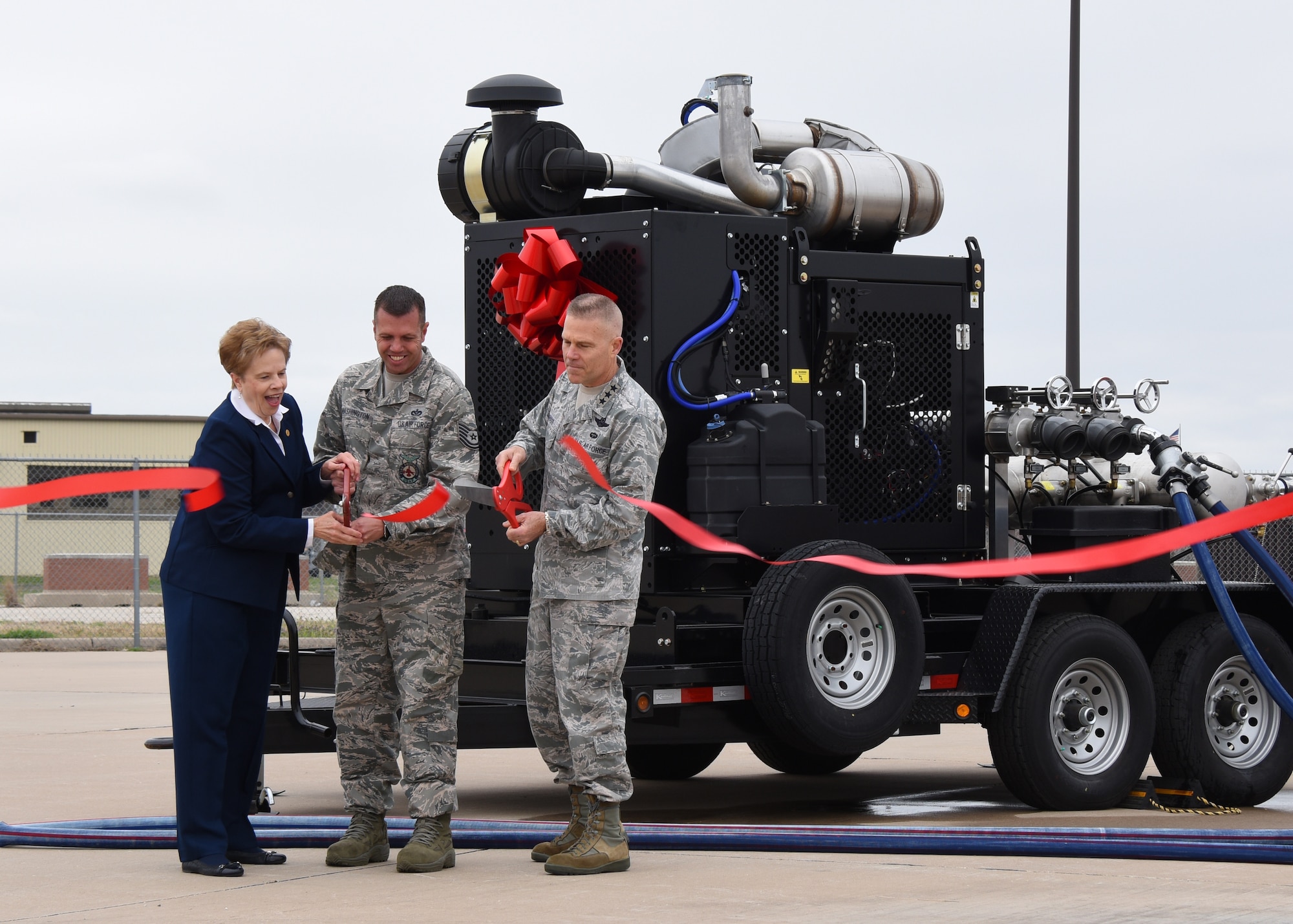 Dr. Carol Bonds, U.S. Air Force Tech. Sgt. Jayton Washington, 312th Training Squadron instructor, and Lt. Gen. Steve Kwast, commander of Air Education and Training Command, cut the ribbon for a new mobile fire pump at the Louis F. Garland Department of Defense Fire Academy on Goodfellow Air Force Base, Texas, March 20, 2019. Thanks to help from Bonds family and the city of San Angelo, Goodfellow was able to purchase four new pumps. (U.S. Air Force photo by Airman 1st Class Zachary Chapman/Released)