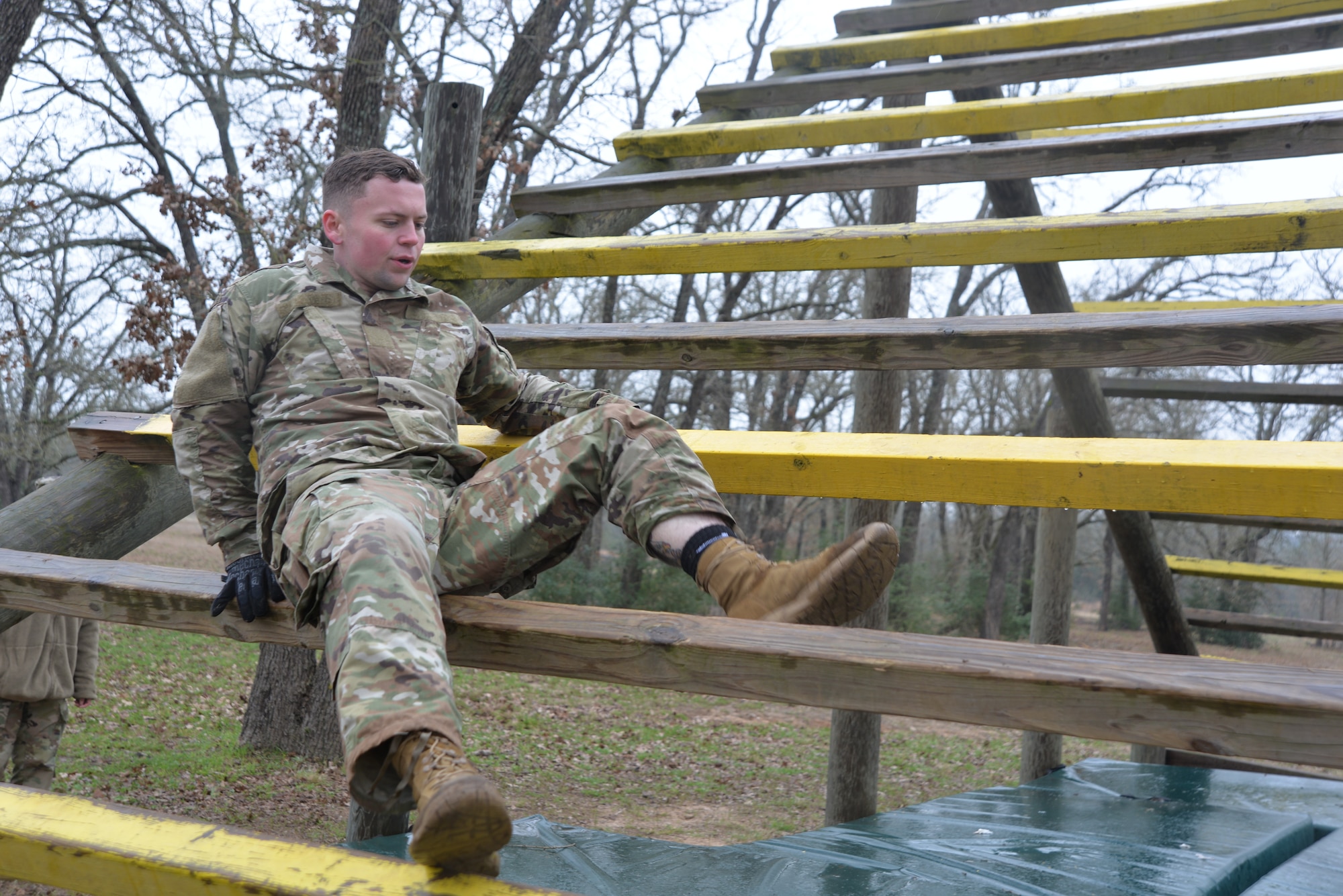 Spc. Tanner Rider, Texas Army National Guard, works his way over and under the wooden beams during the obstacle course portion of the Texas National Guard’s 2019 Best Warrior Competition at Camp Swift Feb. 28, 2019. Over the span of 24 hours, the competitors have been put through an obstacle course, nighttime navigation, a 12-mile ruck march wearing a 35-pound ruck sack and performing a modified Army physical fitness test which consisted of pushups, sit-ups, and a four-mile run. (Texas Air National Guard photo by Senior Airman Bryan Swink)