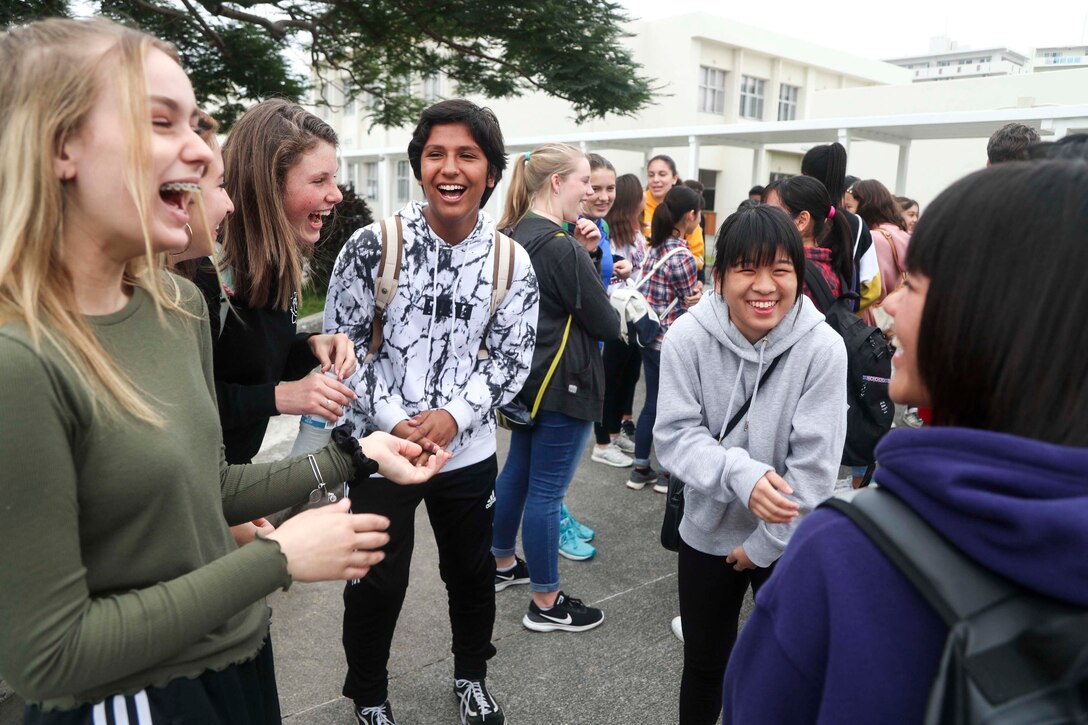 北谷中学校とアメリカンスクールの中学生が、基地内にある北谷城跡で初めての文化交流を行い、笑顔で会話を楽しんでいます。