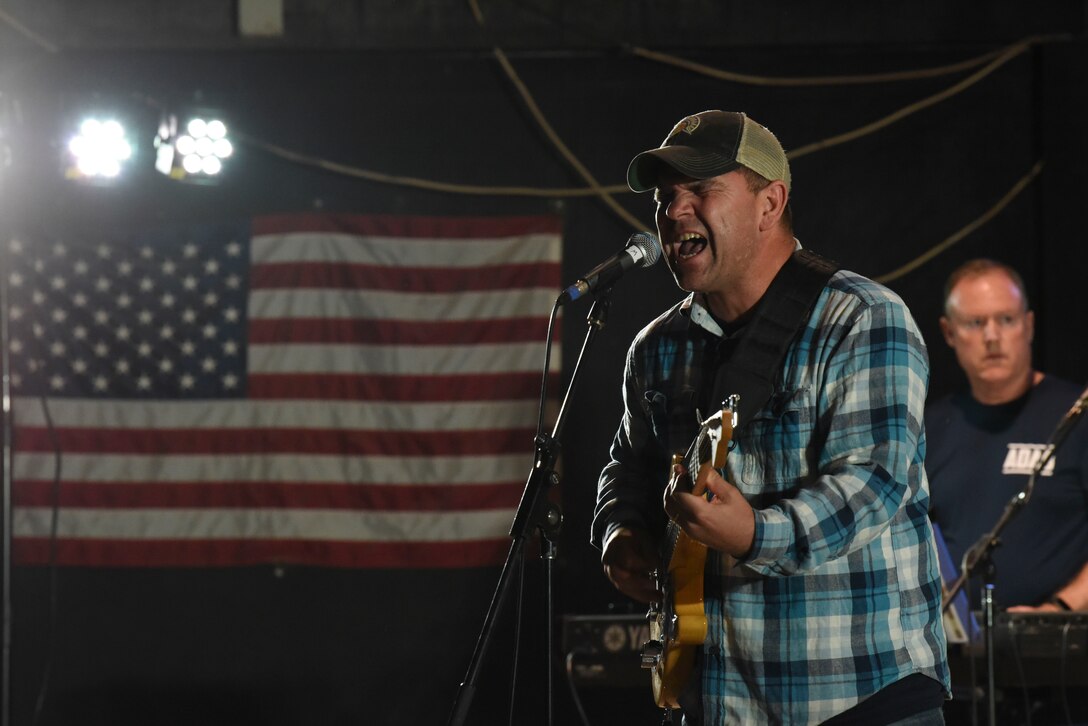 Air Forces Central Command band member Staff Sgt. Ryan Manzi sings a song for the crowd of deployed members at Al Dhafra Air Base, United Arab Emirates, Mar. 20, 2019.