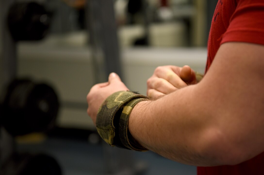 Staff Sgt. Thomas Buena, 14th Contracting Squadron NCO in charge of Base Operating, Support and Services team, adjust lifting straps March 8, 2019, on Columbus Air Force Base, Mississippi. Buena found his passion for powerlifting while on a deployment in 2015 and was second place at the 2019 USA Powerlifting Military Nationals. (U.S. Air Force photo by Airman 1st Class Keith Holcomb)